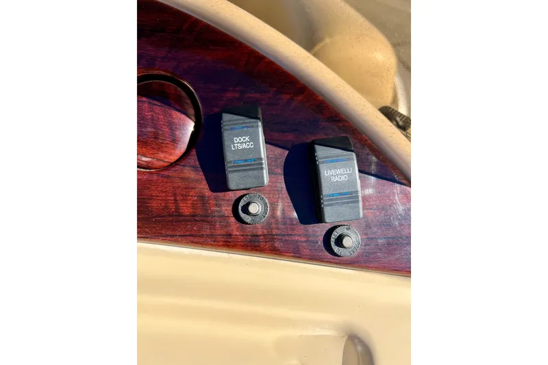 Slide: The Image of Dashboard switches on a 2013 South Bay 417 CR boat, labeled "Dock LTS/ACC" and "Livewell/Radio." - 48