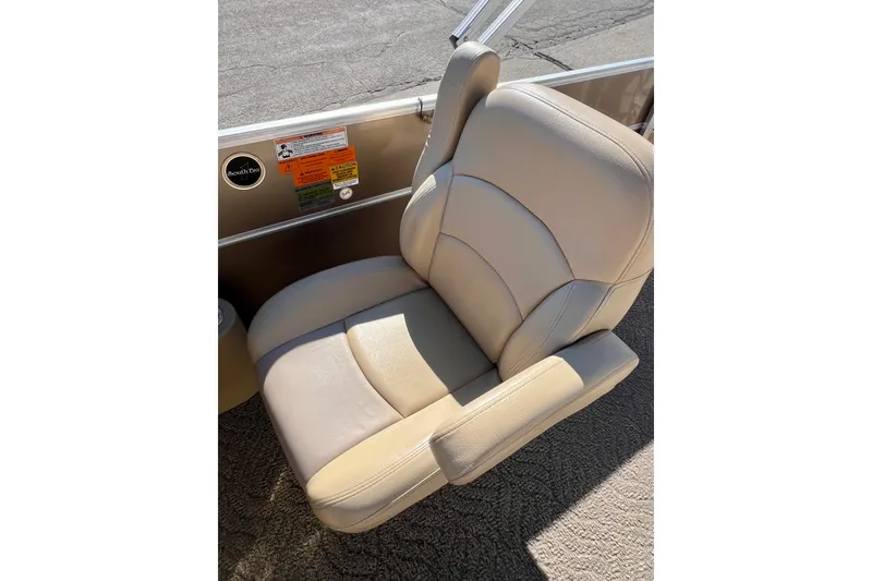 Slide: The Image of Beige boat seat in a 2013 South Bay 417 CR, with safety labels visible. - 24