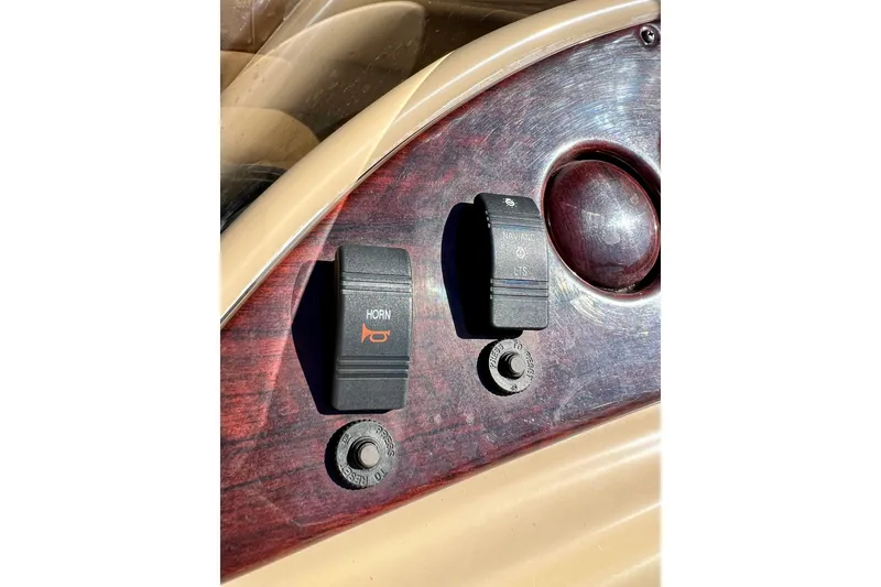Slide: The Image of Dashboard controls of a 2013 South Bay 417 CR boat, featuring horn and navigation switches. - 47