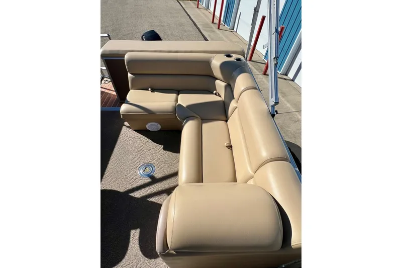Slide: The Image of Beige seating on 2013 South Bay 417 CR pontoon boat, docked near blue storage units. - 25
