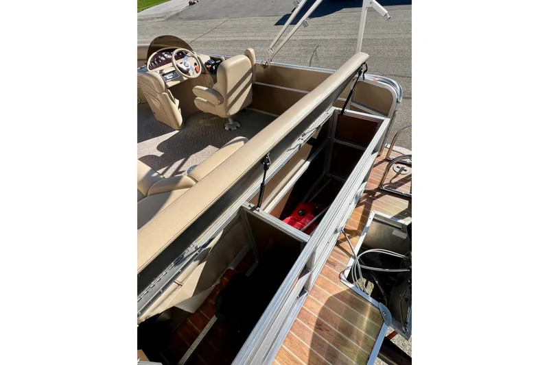 Slide: The Image of 2013 South Bay 417 CR boat interior with open storage compartments and beige seating. - 36