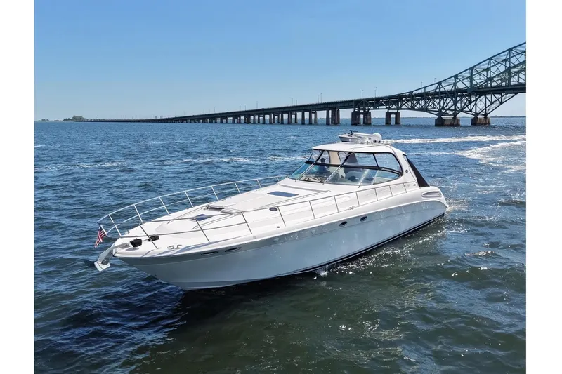 Slide: The Image of 2003 Sea Ray 550 Sundancer yacht cruising near a bridge on a sunny day. - 3
