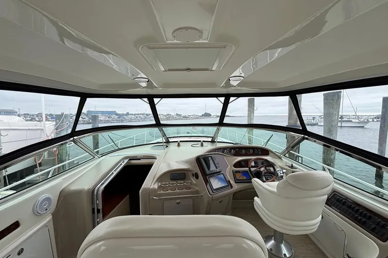 Slide: The Image of 2003 Sea Ray 550 Sundancer helm with panoramic marina view and modern navigation equipment. - 4