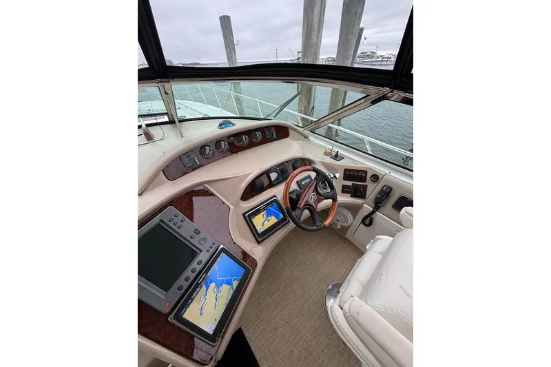 Slide: The Image of 2003 Sea Ray 550 Sundancer helm with navigation screens and steering wheel. - 7