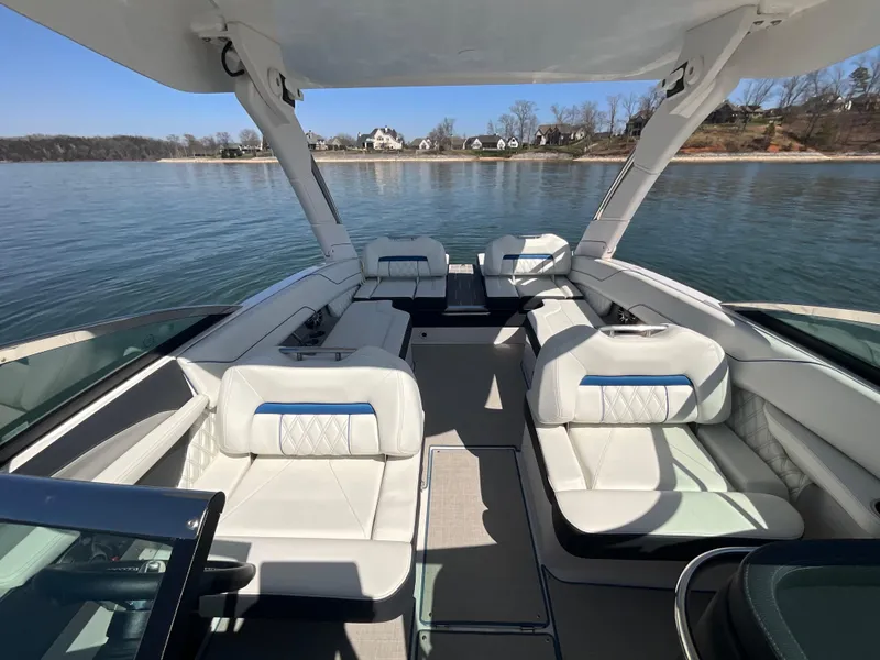 Slide: The Image of 2023 Regal LS6 boat interior with luxurious seating on a serene lake. - 16