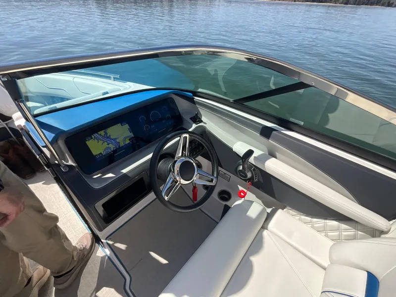 Slide: The Image of 2023 Regal LS6 boat interior with modern dashboard and steering wheel on a sunny day. - 17