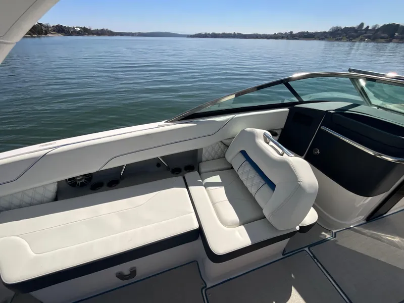 Slide: The Image of 2023 Regal LS6 boat interior with white seating, on a calm lake. - 15