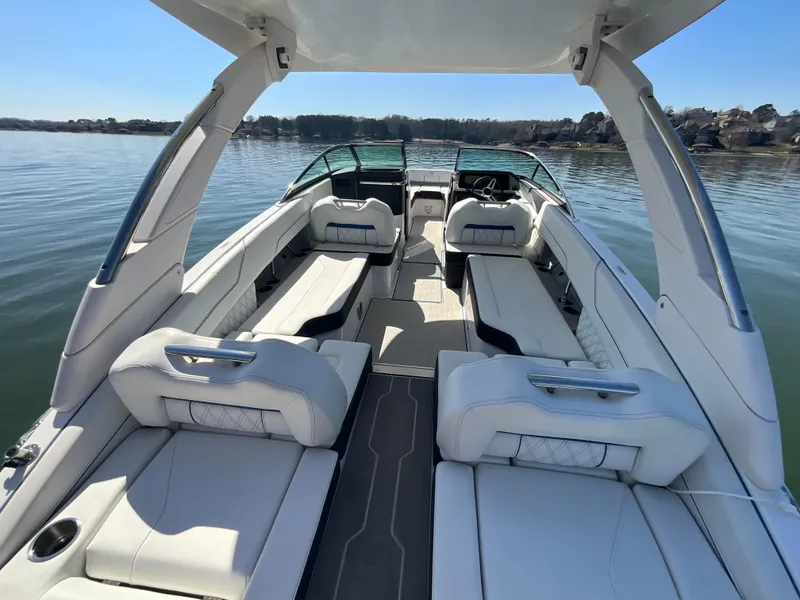 Slide: The Image of 2023 Regal LS6 boat interior with luxurious seating on a calm lake. - 20