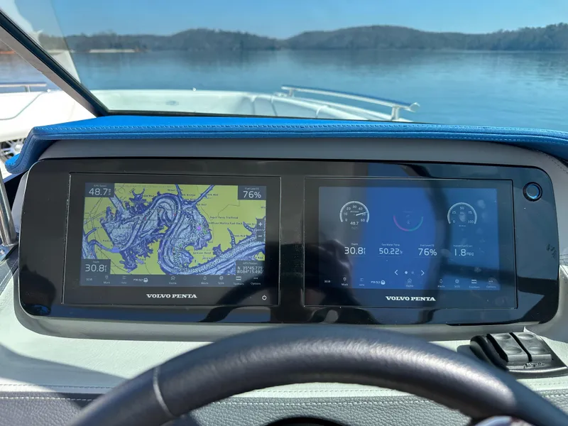 Slide: The Image of Dashboard of 2023 Regal LS6 boat with dual Volvo Penta displays on a lake. - 21