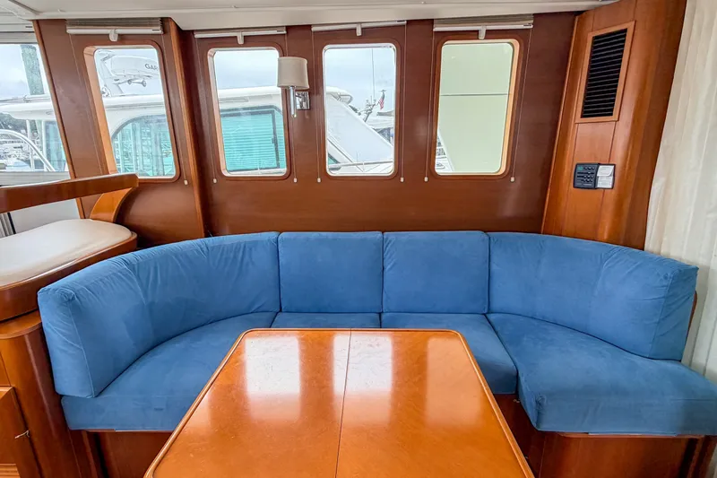 Slide: The Image of Interior of 2006 Beneteau Swift Trawler 42 with blue sofa and wooden table. - 7