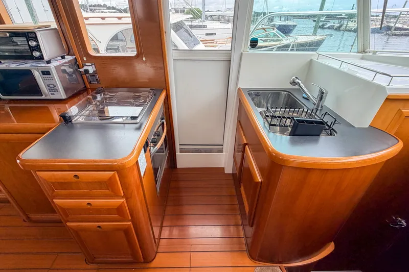 Slide: The Image of 2006 Beneteau Swift Trawler 42 kitchen with stove, sink, and wooden cabinetry. - 5