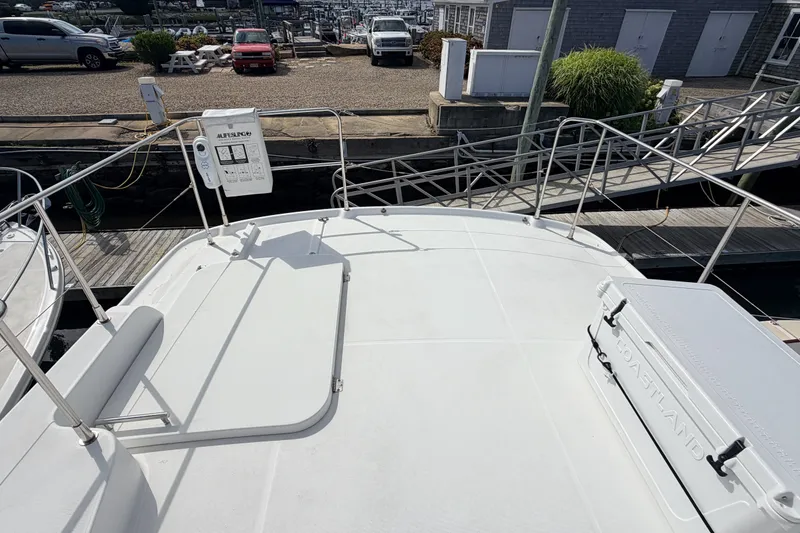 Slide: The Image of 2006 Beneteau Swift Trawler 42 deck view at marina, featuring safety railings and equipment. - 26