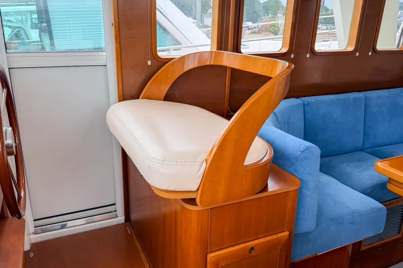 Slide: The Image of Interior of 2006 Beneteau Swift Trawler 42 with wooden helm seat and blue sofa. - 10