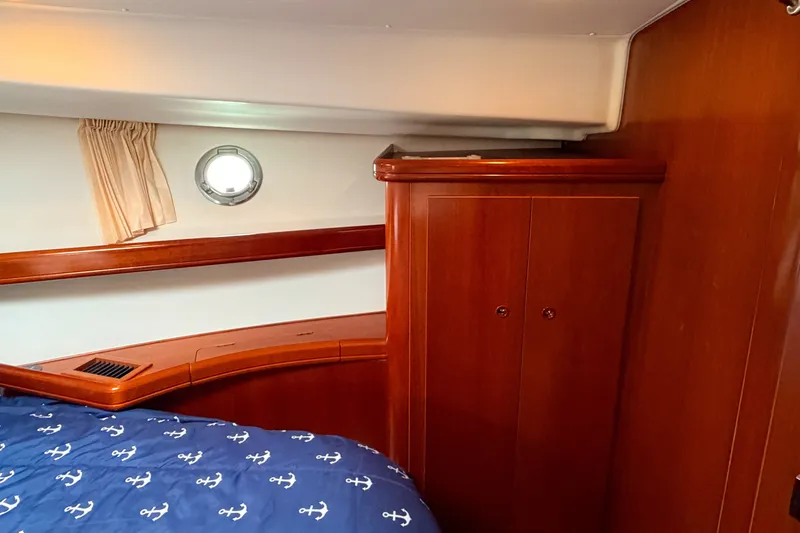 Slide: The Image of Interior cabin of 2006 Beneteau Swift Trawler 42 with wooden cabinetry and nautical-themed bedding. - 15