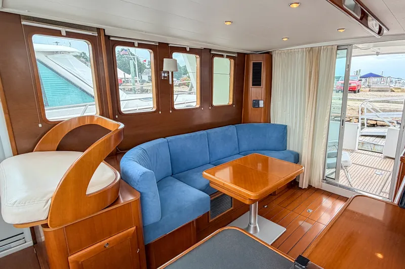 Slide: The Image of Interior of 2006 Beneteau Swift Trawler 42 with blue sofa and wooden table. - 2