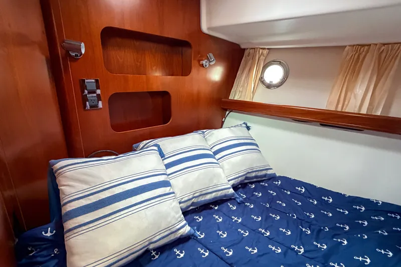 Slide: The Image of Cozy cabin interior of 2006 Beneteau Swift Trawler 42 with nautical-themed bedding. - 13