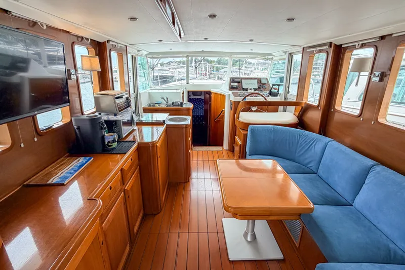 Slide: The Image of Interior of 2006 Beneteau Swift Trawler 42 with wood finish and blue seating. - 1