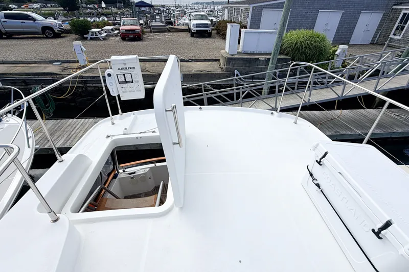 Slide: The Image of 2006 Beneteau Swift Trawler 42 docked, showcasing deck and open hatch. - 27