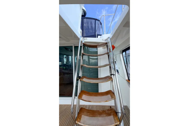 Slide: The Image of Staircase on 2006 Beneteau Swift Trawler 42, leading to upper deck, with blue sky above. - 20