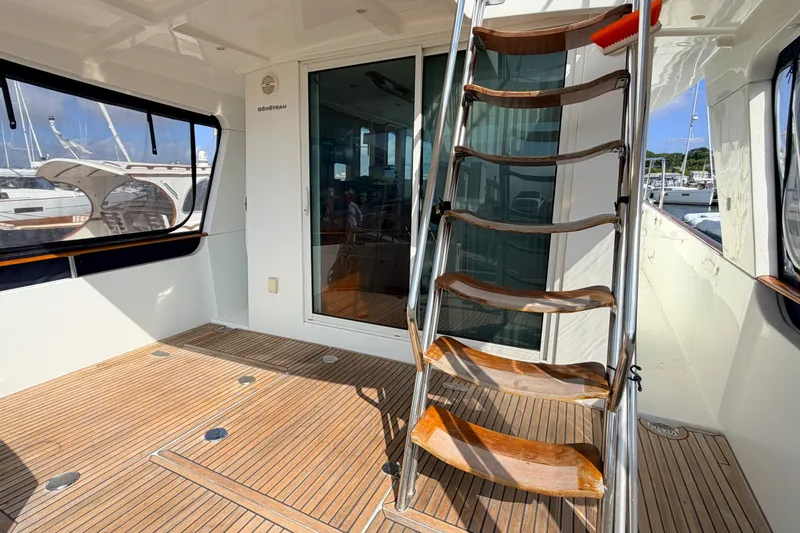 Slide: The Image of 2006 Beneteau Swift Trawler 42 interior with wooden flooring and metal staircase. - 16