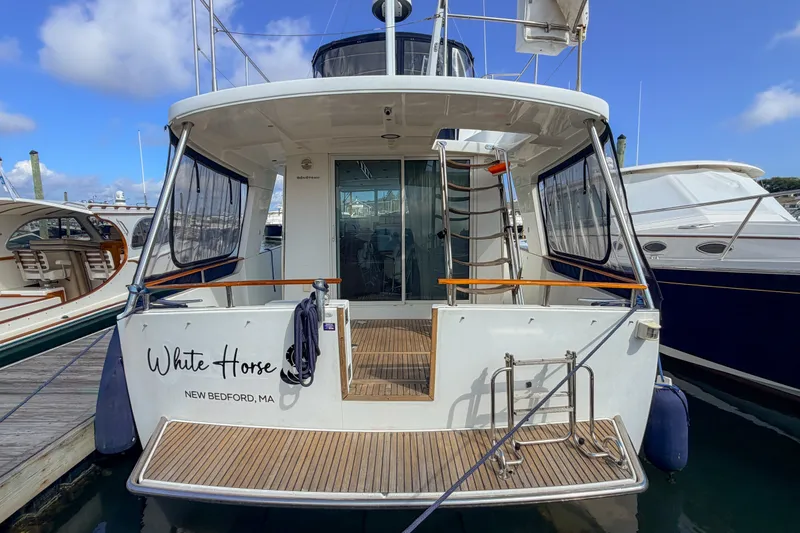 Slide: The Image of 2006 Beneteau Swift Trawler 42 docked, rear view with "White Horse" name visible. - 18