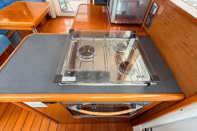 Slide: The Image of 2006 Beneteau Swift Trawler 42 kitchen with stove and wooden cabinetry. - 6