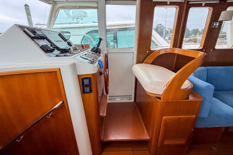 Slide: The Image of Interior helm station of 2006 Beneteau Swift Trawler 42 with wooden finish and seating. - 9