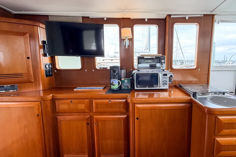 Slide: The Image of Interior of 2006 Beneteau Swift Trawler 42 with kitchen appliances and wooden cabinetry. - 3