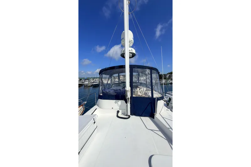 Slide: The Image of 2006 Beneteau Swift Trawler 42 docked, showcasing upper deck and blue canopy. - 22