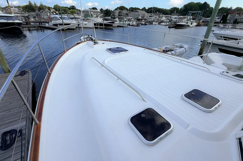 Slide: The Image of 2006 Beneteau Swift Trawler 42 docked at marina, showcasing spacious deck and hatches. - 30