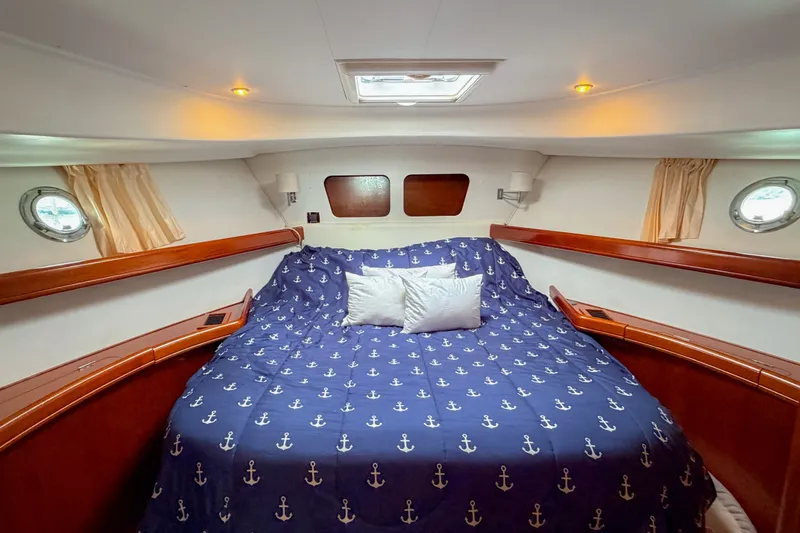 Slide: The Image of Cozy cabin interior of 2006 Beneteau Swift Trawler 42 with nautical-themed bedding. - 14