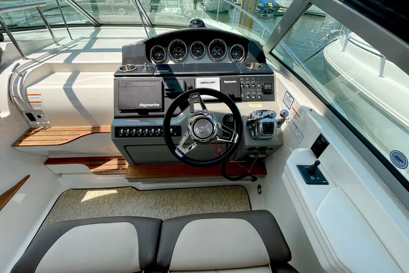 Slide: The Image of 2015 Sea Ray Sundancer 350 helm with steering wheel, gauges, and navigation controls. - 13