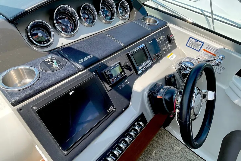 Slide: The Image of Helm of 2015 Sea Ray Sundancer 350 with gauges, controls, and steering wheel. - 14
