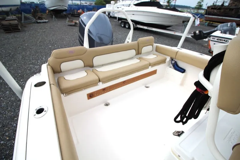 Slide: The Image of 2018 Key West 239 FS boat interior with beige seating and engine view. - 17