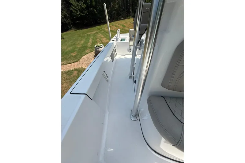 Slide: The Image of 2022 Sportsman Masters 227 Bay Boat interior with seating and railing, outdoors. - 13