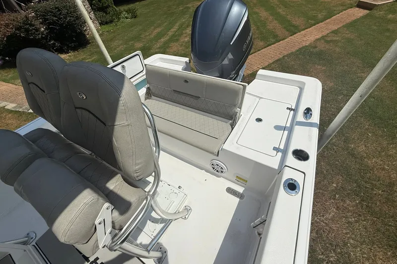 Slide: The Image of 2022 Sportsman Masters 227 Bay Boat interior with seating and engine view. - 16