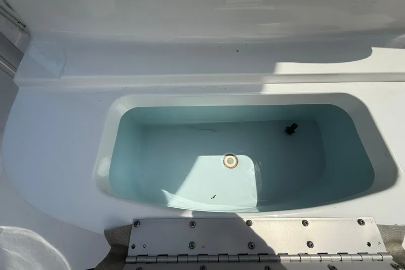 Slide: The Image of Livewell compartment on a 2022 Sportsman Masters 227 Bay Boat, partially filled with water. - 15