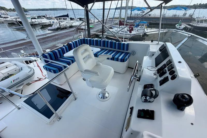 Slide: The Image of Flybridge of 2016 Nordic Tug 44 with striped seating and helm, docked at marina. - 25
