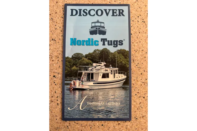 Slide: The Image of Discover Nordic Tug 44, 2016 model, cruising on serene waters with lush greenery backdrop. - 115