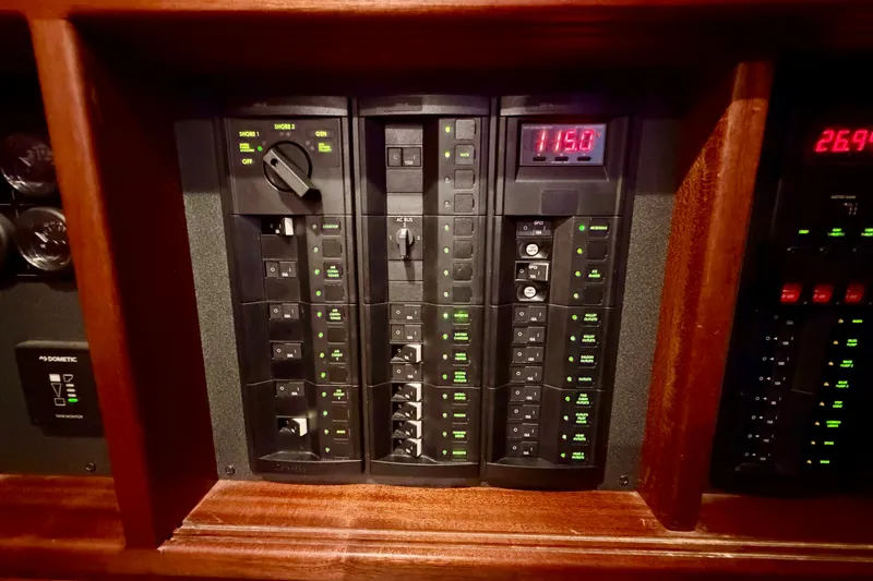 Slide: The Image of Electrical control panel on a 2016 Nordic Tug 44 boat, featuring switches and digital displays. - 70