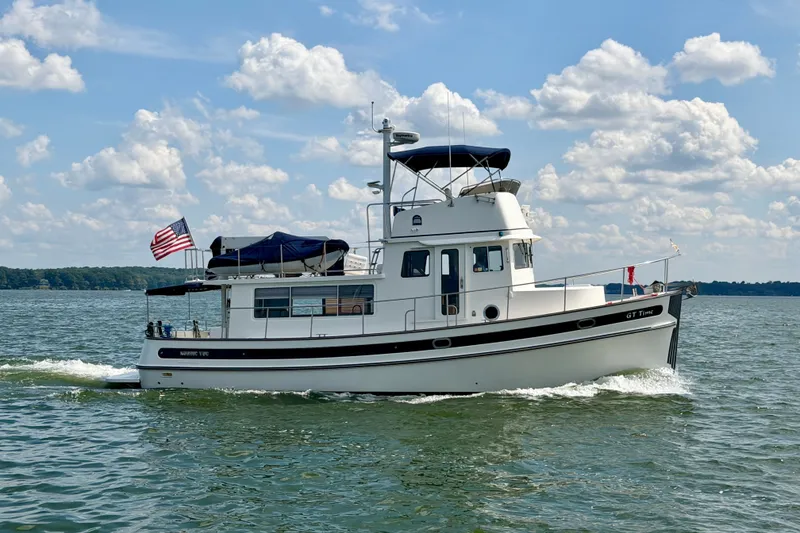Slide: The Image of 2016 Nordic Tug 44 cruising on a sunny day with American flag. - 2