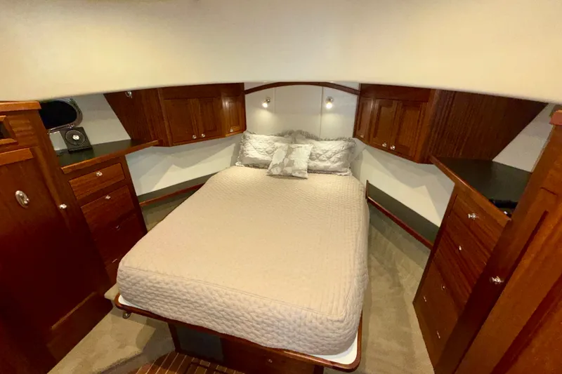 Slide: The Image of Luxurious cabin interior of a 2016 Nordic Tug 44 with wood cabinetry and cozy bedding. - 81