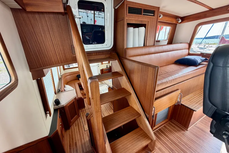 Slide: The Image of Interior of 2016 Nordic Tug 44, featuring wooden stairs and seating area. - 49
