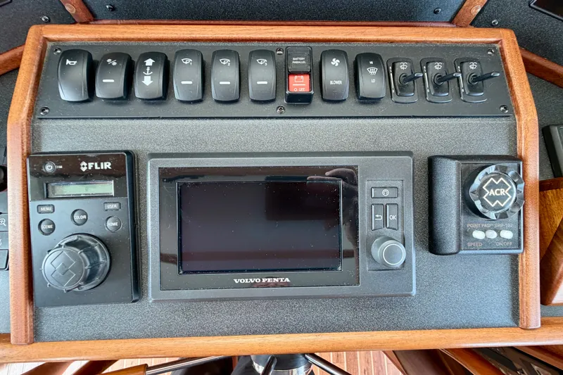 Slide: The Image of Control panel of a 2016 Nordic Tug 44 with navigation and system switches. - 58