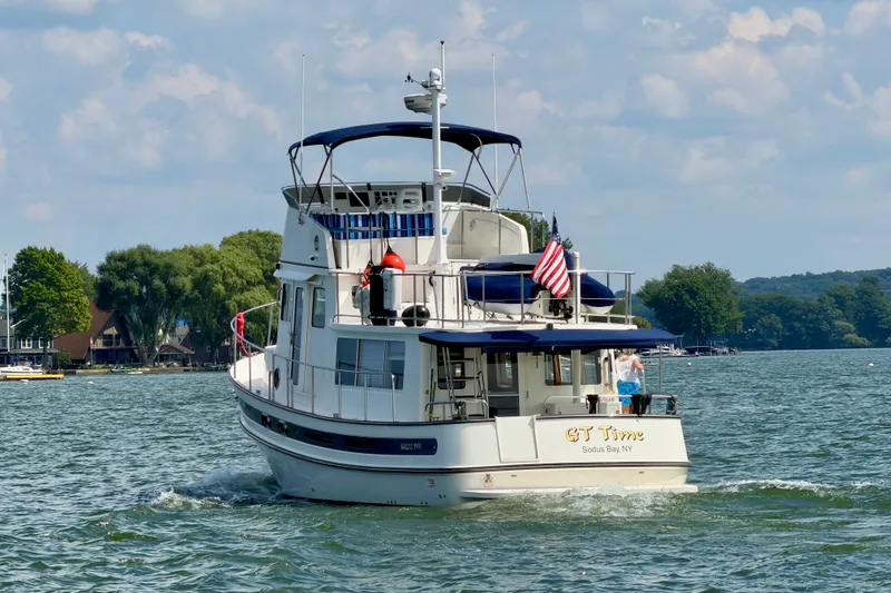 Slide: The Image of Nordic Tug 44 boat cruising on a lake, 2016 model, with American flag displayed. - 1