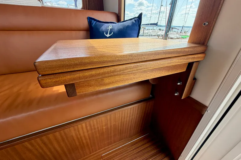 Slide: The Image of Interior of 2016 Nordic Tug 44 with wooden table and anchor-themed cushion. - 52