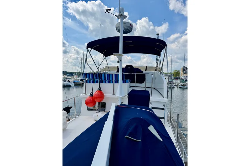 Slide: The Image of 2016 Nordic Tug 44 yacht with blue canopy docked at marina under cloudy sky. - 21