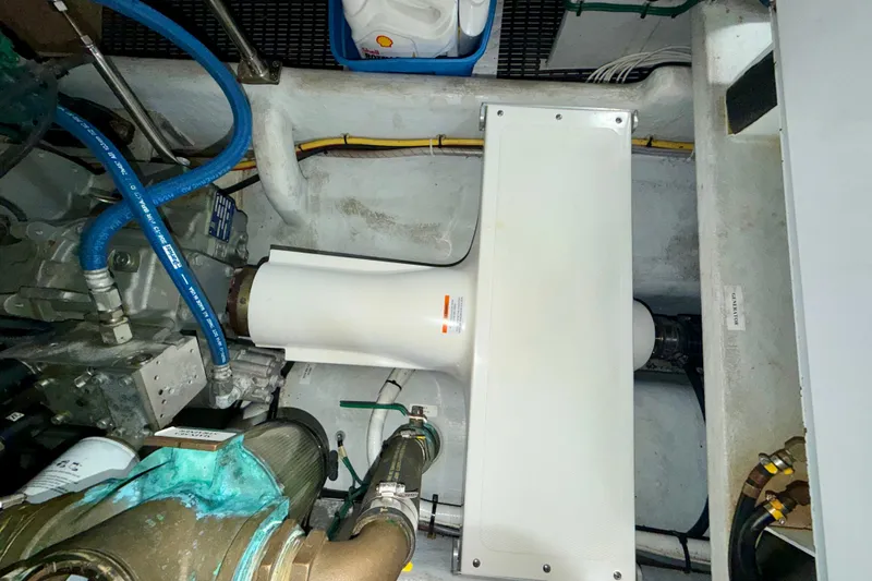 Slide: The Image of Engine room of a 2016 Nordic Tug 44, featuring mechanical components and hoses. - 102