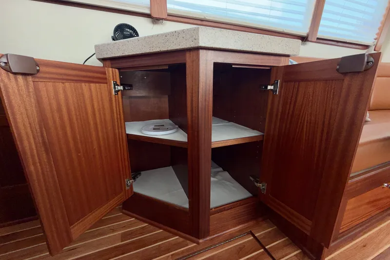 Slide: The Image of Open wooden cabinet inside 2016 Nordic Tug 44 boat, showcasing interior storage space. - 43