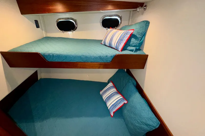 Slide: The Image of Bunk beds in 2016 Nordic Tug 44 cabin with blue bedding and striped pillows. - 75